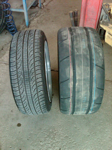 2011 Ford Mustang - A comparison of two different tire types is shown on a garage floor.