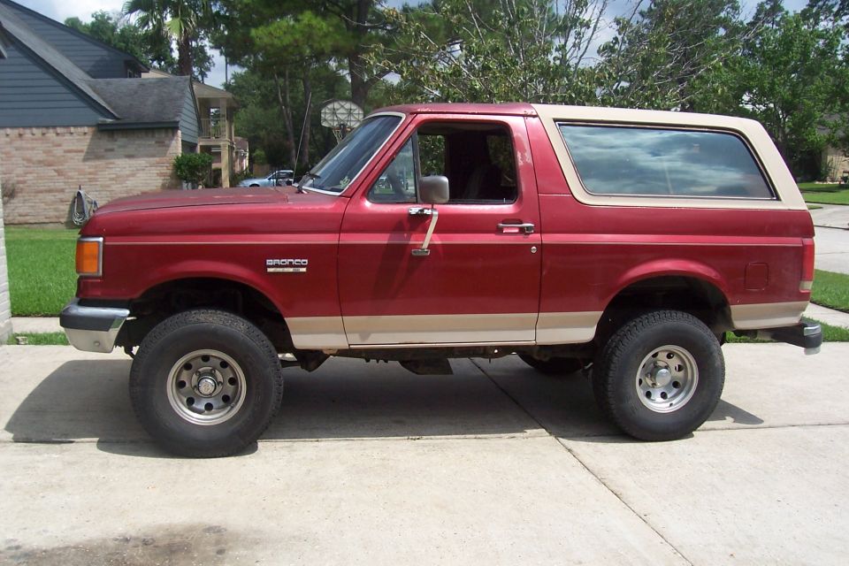 Side view of red 1988 Ford Bronco with tan trim