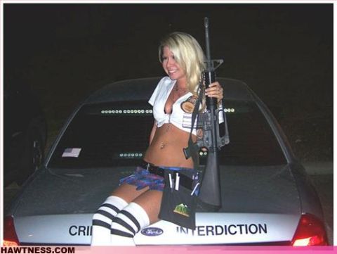 2000 Mercury Grand Marquis - A woman poses with a rifle on the trunk of a car that has 'INTERDICTION' written on it.