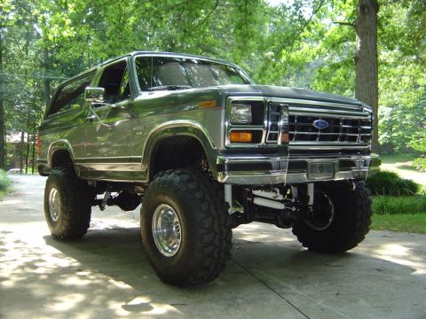 1986 Ford Bronco - This lifted 1986 Ford Bronco features a prominent chrome grille and aggressive off-road tires.