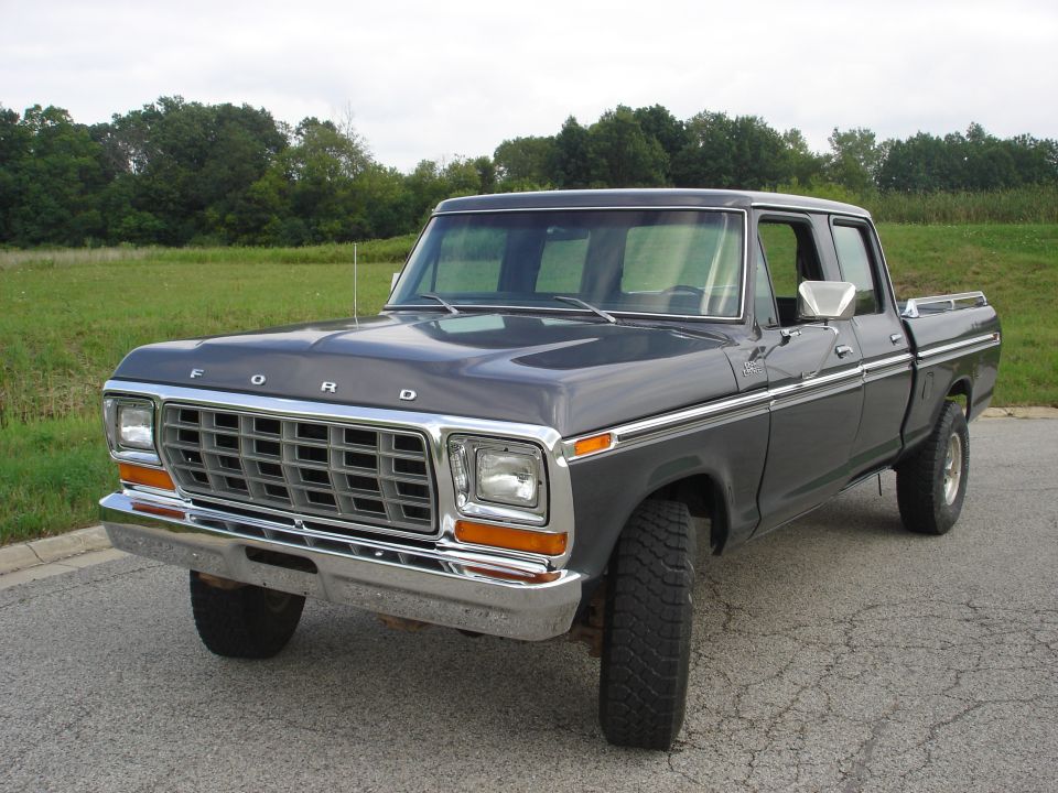 1979 Ford F-250 Crew Cab pickup truck, dark gray, parked on asphalt with grassy field behind