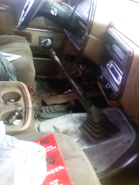 1990 Ford Bronco - The interior of a vehicle shows a floor shifter and dashboard details, with a K&N air filter box in the foreground.