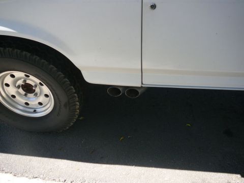 1988 Ford Bronco - Dual exhaust pipes are visible on the lower side of a white vehicle.