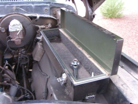 1978 Ford Bronco - Engine bay of a 1978 Ford Bronco, an open toolbox with a tool inside.