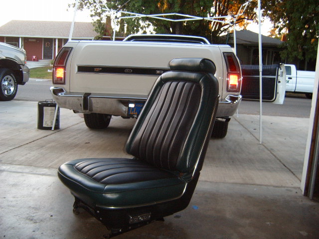car seat in front of a white pickup truck bed and tailgate