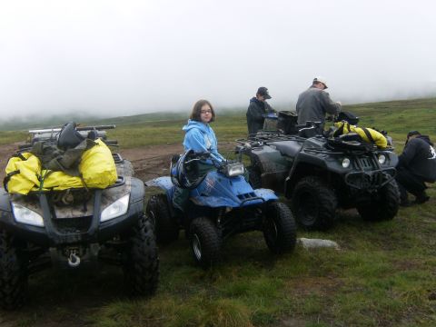 2000 Ford E350 - A group of people and their ATVs are gathered on a grassy, muddy area under a foggy sky.