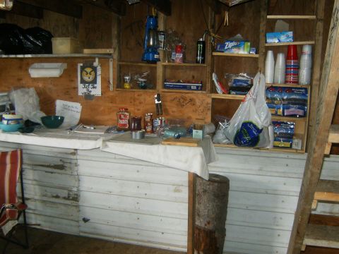 2000 Ford E350 - The interior of a cabin shows shelves filled with various supplies and a table set with food and bowls.
