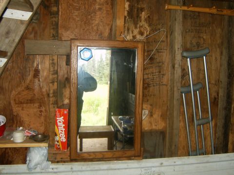 2000 Ford E350 - Interior of a rustic cabin a mirror, crutches, and a Yahtzee box on a shelf.