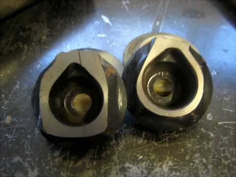 1996 Ford Bronco - Close-up of two machined metal components, possibly for automotive use, on a workbench.