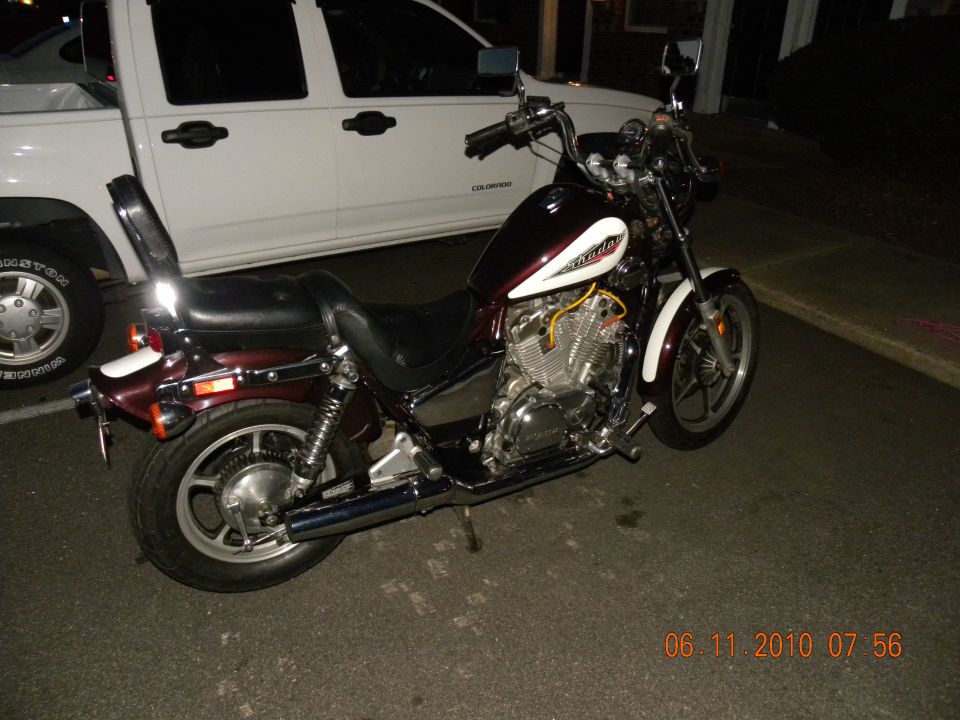 Maroon and white motorcycle parked next to a white pickup truck