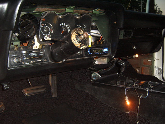 1973 Ford Ranchero interior dashboard with steering column removed, showing gauges, radio, and pedals