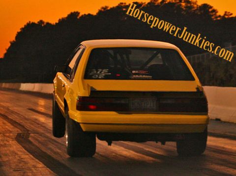 1992 Ford Mustang - This yellow 1992 Ford Mustang is captured from the rear on a drag strip, its roll cage and racing tires.