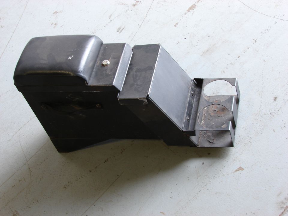 Black center console with two cup holders and a storage compartment