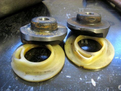1996 Ford Bronco - Close-up of two automotive suspension spring seats and isolators resting on a work surface.