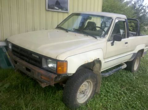 1992 Ford Mustang - This beige Toyota pickup truck is shown from a 3/4 front angle, with the 'TOYOTA' badge clearly visible on the grille.
