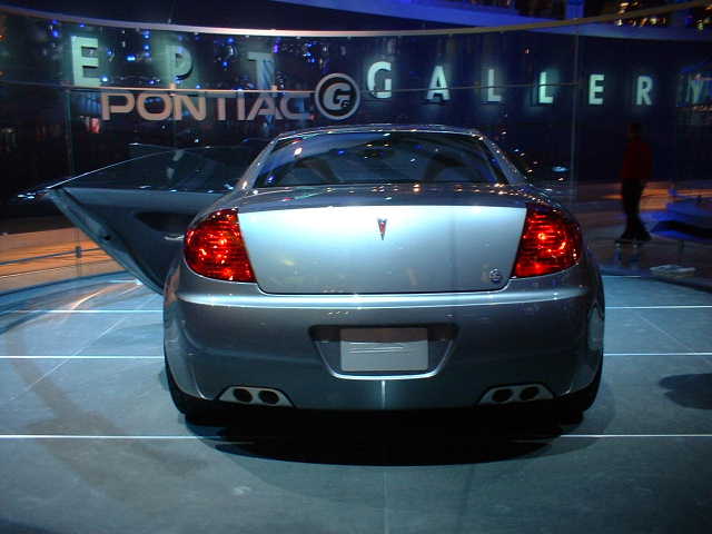 Rear view of a silver Pontiac G6 Coupe with driver's door open, on display