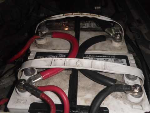 1991 Ford Bronco - Close-up view of two vehicle batteries connected by red and black cables.
