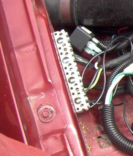 1997 Ford Taurus - A close-up view of automotive electrical components, including wiring and a relay, mounted on a bracket.