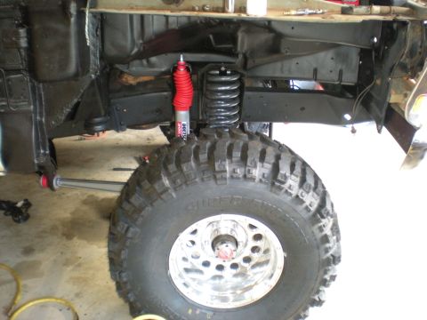 1978 Ford Bronco - The vehicle's suspension system is visible, a red shock absorber and a large coil spring.