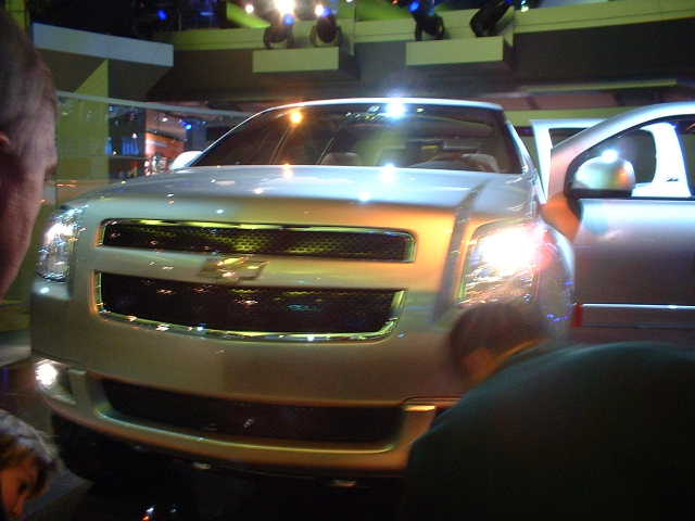 Silver SUV front view with chrome grille and open door