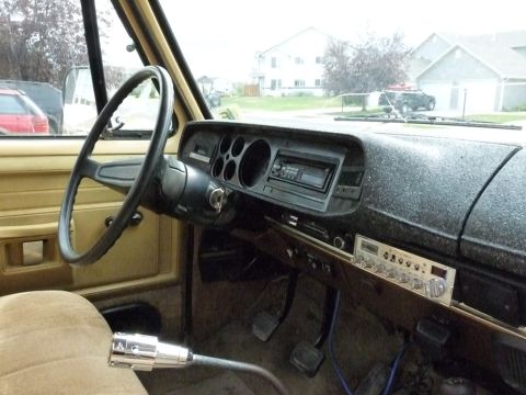 2006 Ford E350 - The interior of an older vehicle, a classic radio and a column shifter.