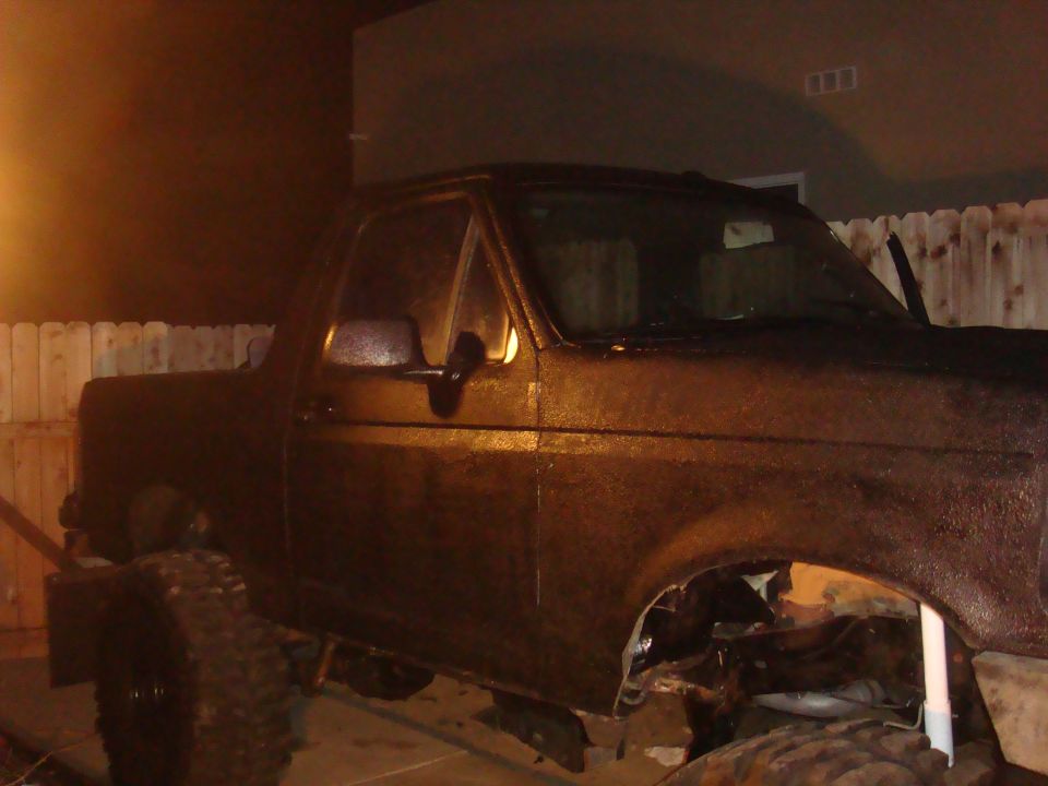 Dark brown 1992 Ford Bronco, front passenger side, with visible rust and missing fender