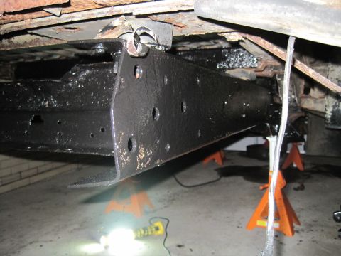 1979 Ford Bronco - Close-up view of vehicle undercarriage components, including frame and suspension parts, undergoing maintenance.