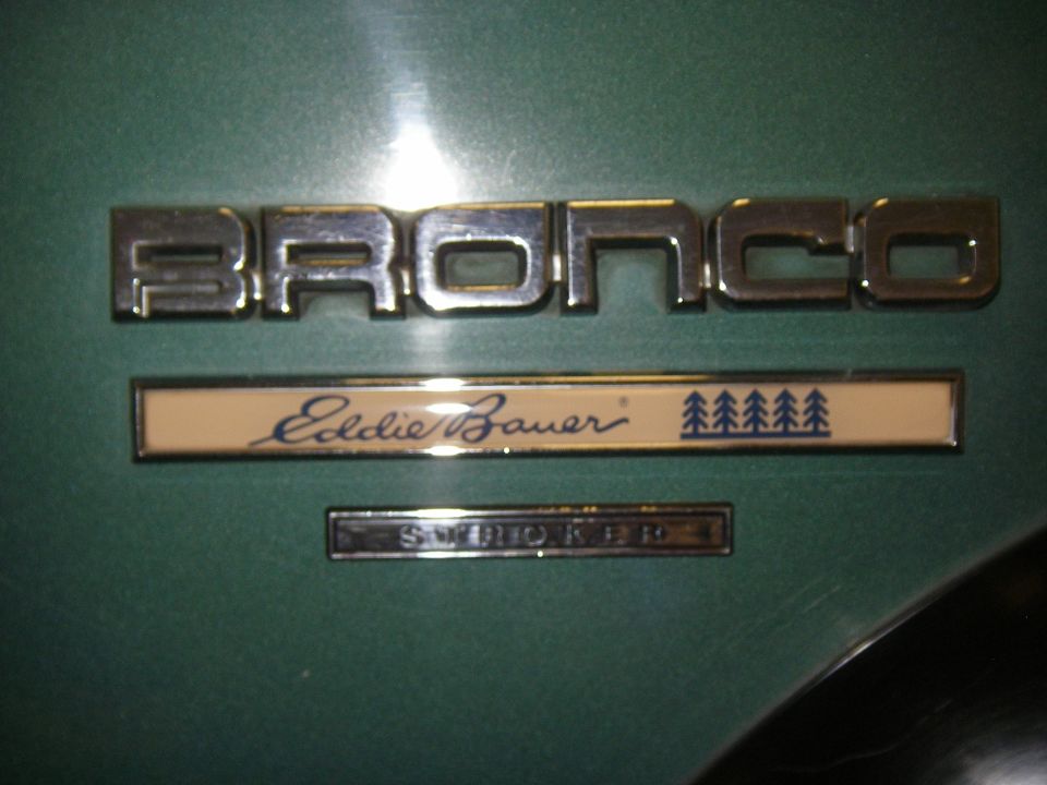Chrome BRONCO, Eddie Bauer, and STROKER badges on green body panel