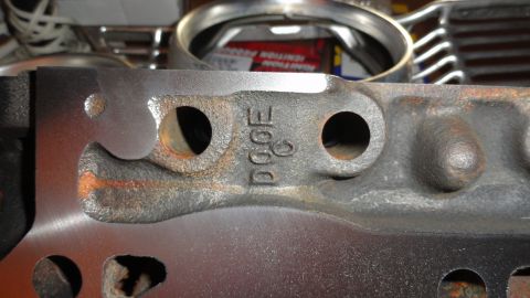 1964 Ford Fairlane - Close-up of an engine part showing casting marks 'DOOF C' and bolt holes, with other engine components visible in the background.