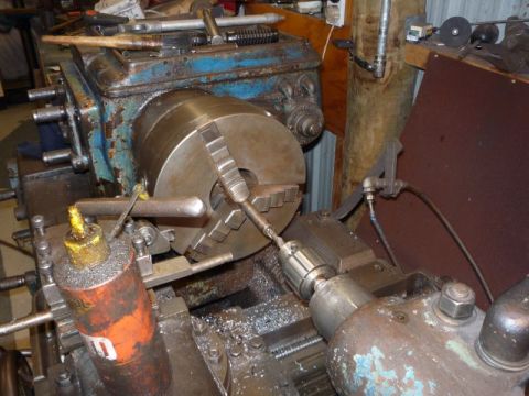 1969 MINI Cooper - A metal lathe is shown with a drill bit in operation, surrounded by metal shavings and oil.