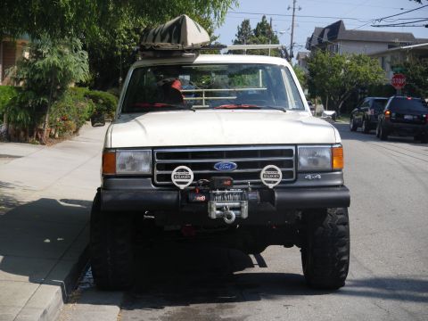 1991 Ford Bronco - This 1991 Ford Bronco features a winch on the front bumper and a roof rack with cargo.
