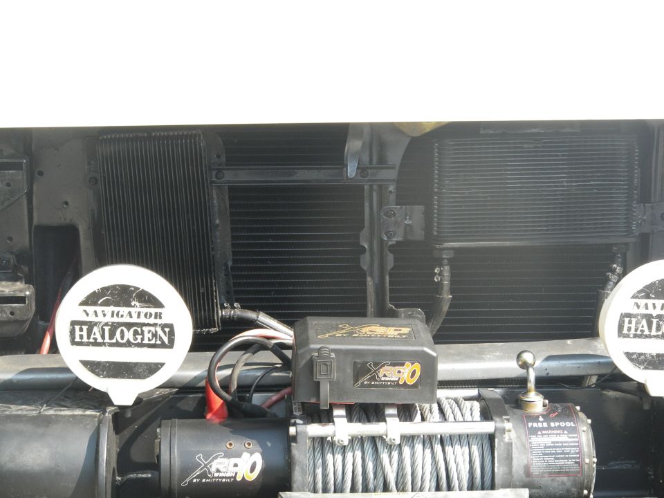 Front of vehicle showing a winch, two halogen lights, and radiators