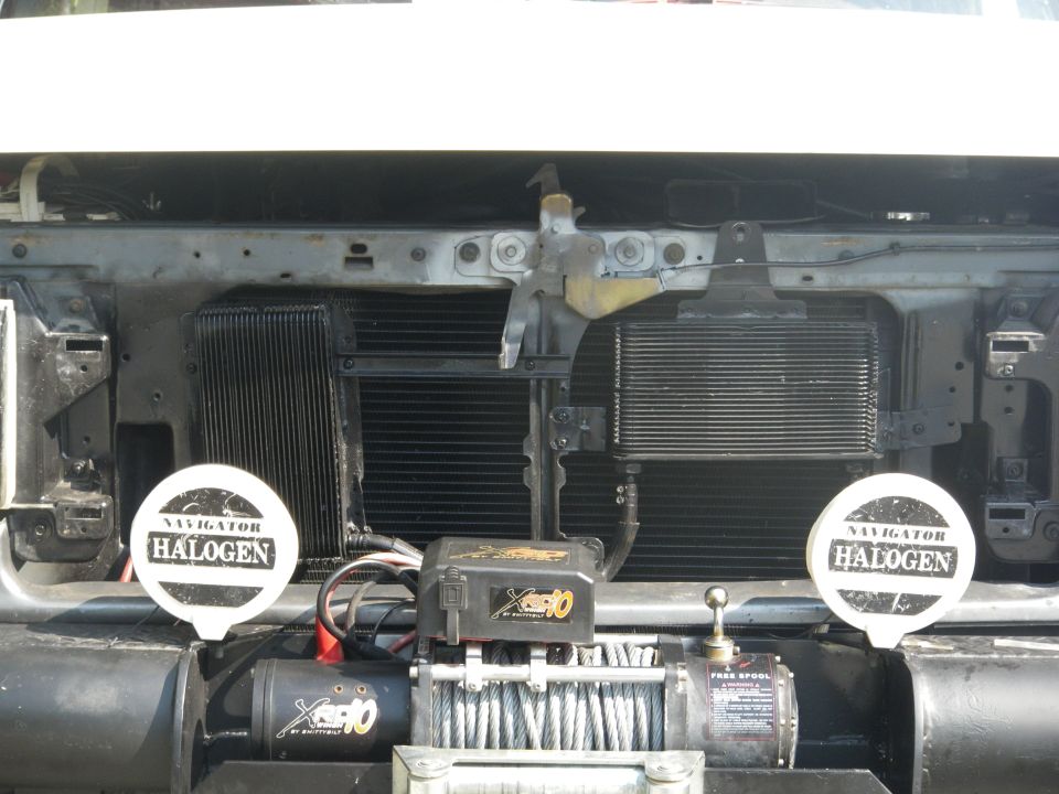 Front view of a white Ford Bronco with a winch and halogen lights