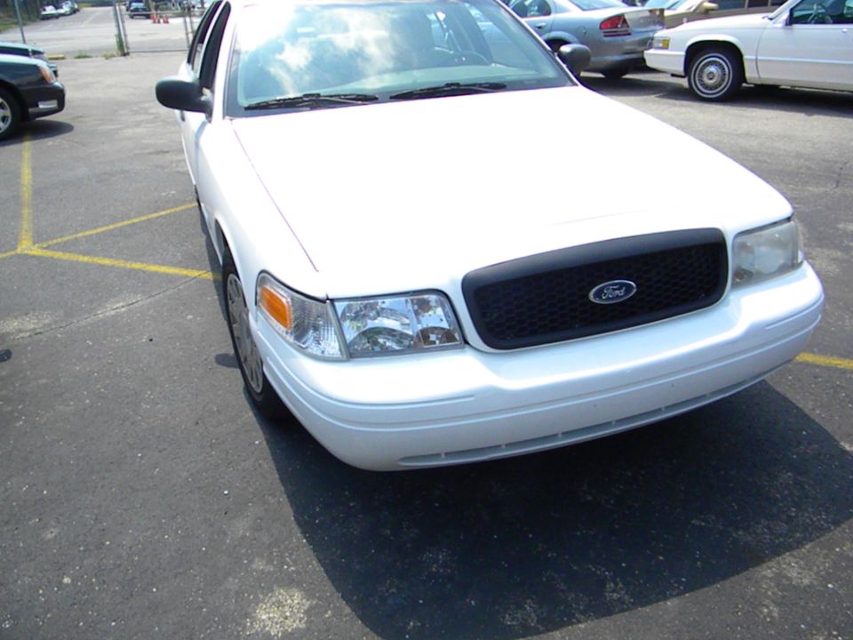 White 2003 Ford Crown Victoria, front 3/4 view, parked in lot