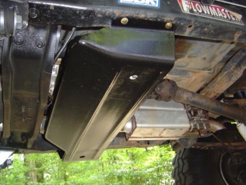 1986 Ford Bronco - Close-up view of the underbody skid plate and driveshaft of an off-road vehicle.