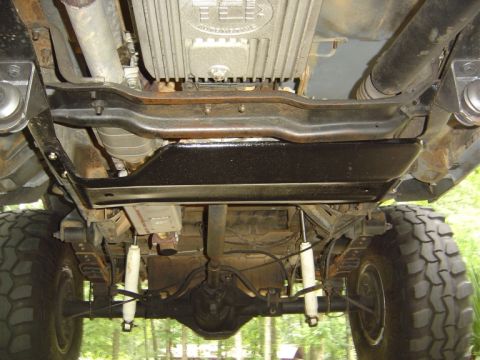1986 Ford Bronco - Vehicle undercarriage with skid plate and suspension components visible.