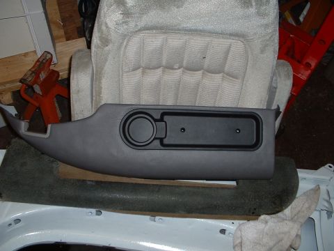 1994 GMC Suburban - Interior trim piece with a cup holder and a storage slot is shown.