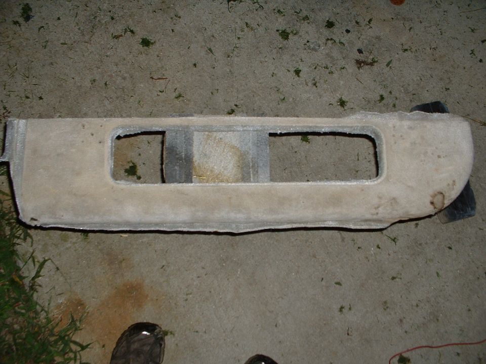 Car interior sun visor with two rectangular cutouts, lying on concrete