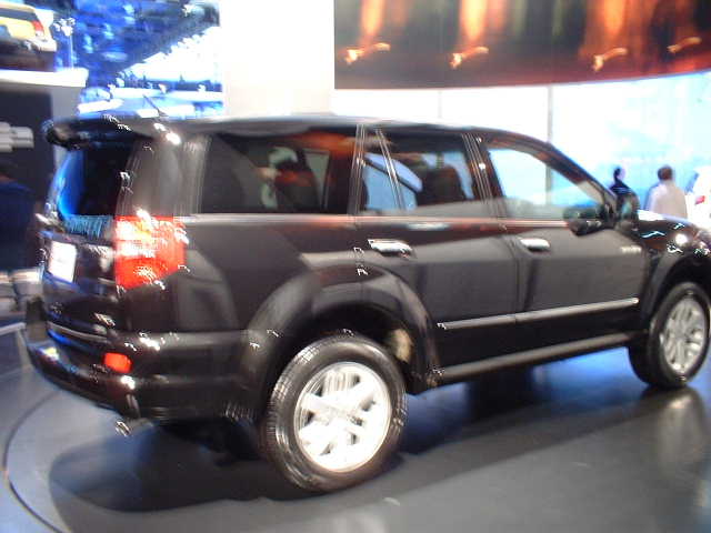 Dark SUV rear quarter view with chrome trim and spoiler