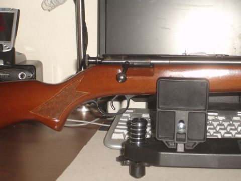 1989 Ford Bronco - A close-up view of a rifle's wooden stock and metallic receiver, resting on a stand.