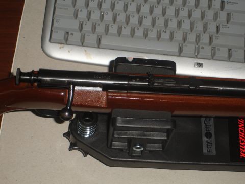 1989 Ford Bronco - Rifle with wooden stock rests on a black stand, with a computer keyboard behind it.