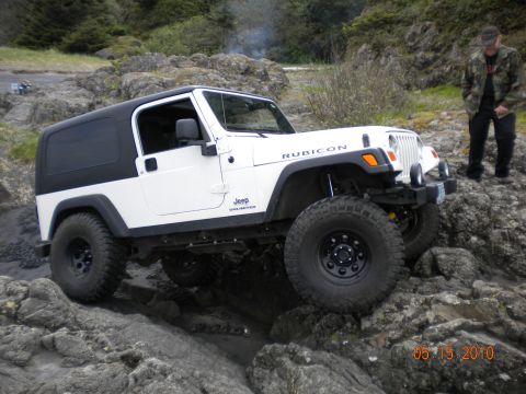 2005 Jeep Wrangler - A white 2005 Jeep Wrangler Rubicon is shown off-roading on a rocky coastal path.