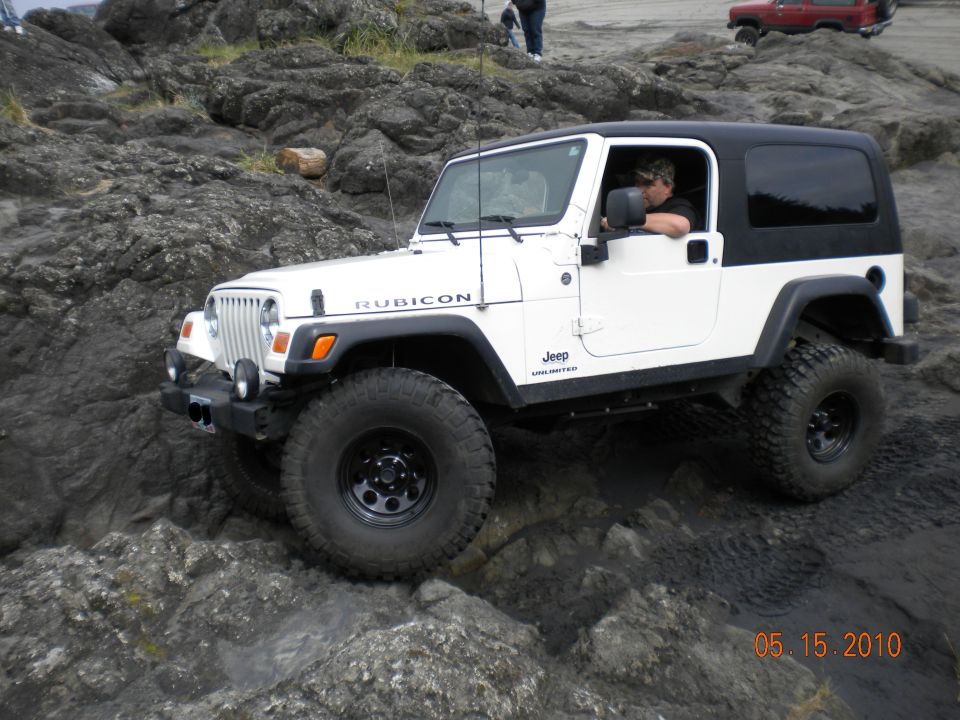 White Jeep Wrangler Rubicon driving over rocks. Date stamp 05.15.2010