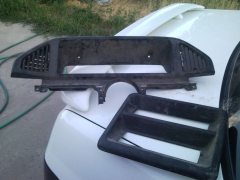 1989 Ford Bronco - These dashboard trim pieces are shown resting on the hood of a white vehicle.