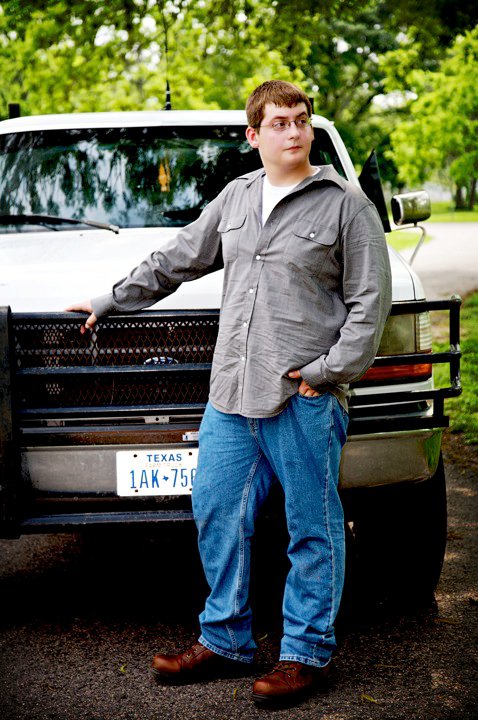 1996 Ford Bronco - A man poses next to a white 1996 Ford Bronco, which features a black grille guard and a Texas license plate.