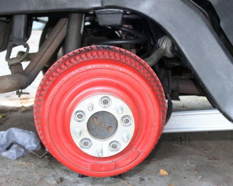 1976 Ford Ranchero - Detail shot of a vehicle's wheel and suspension system, showing painted components.