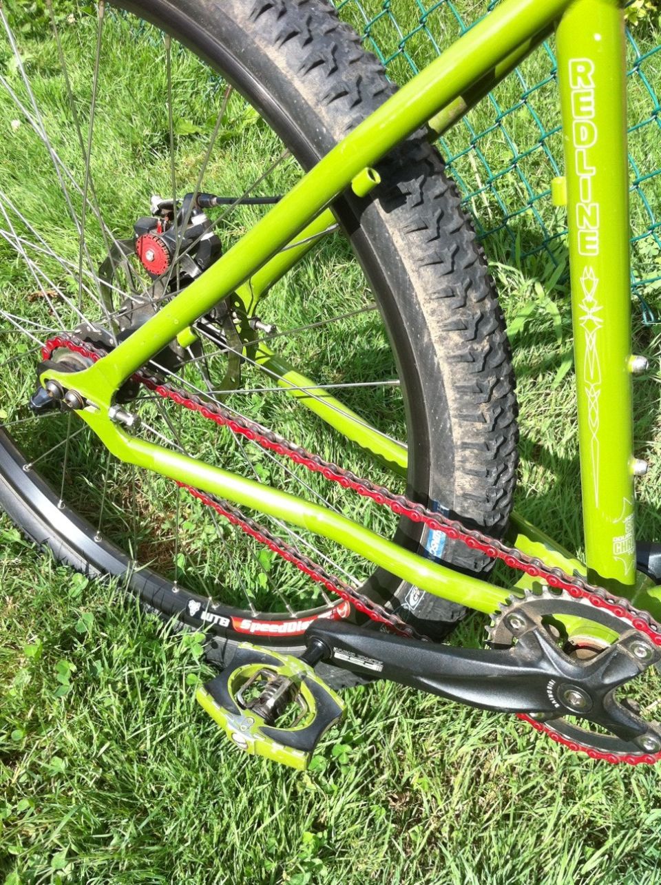 Lime-green Redline mountain bike drivetrain close-up on grass