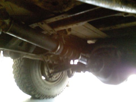 1990 Ford Bronco - Underside view of a vehicle's drivetrain components, including the rear axle and driveshaft.