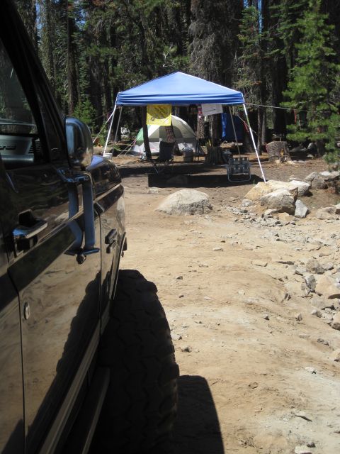 1989 Ford Bronco - A black SUV is parked at a campsite with tents and a canopy visible in the background.
