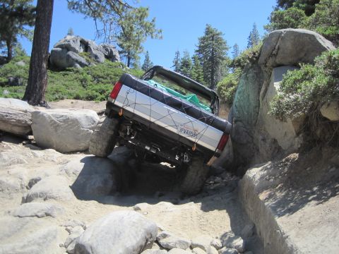 1989 Ford Bronco - This 1989 Ford Bronco is shown tackling a challenging off-road course with steep inclines and large rocks.